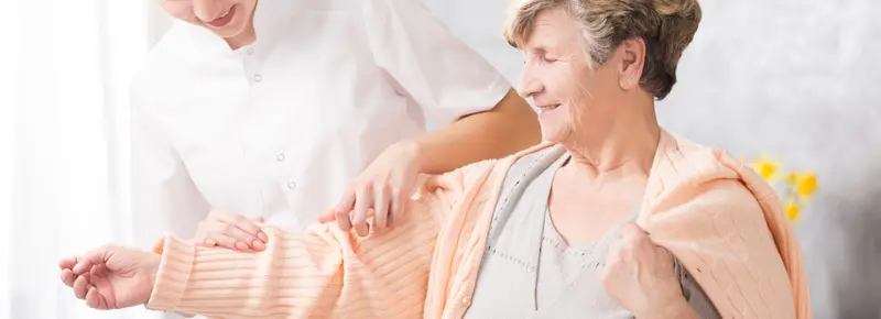 A caregiver warmly hugging an older woman