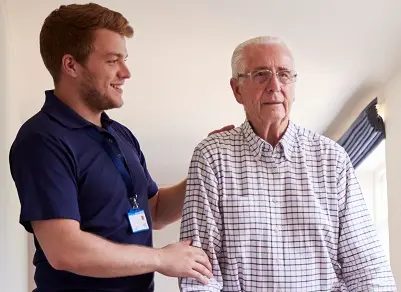 A male caregiver chatting with an older man